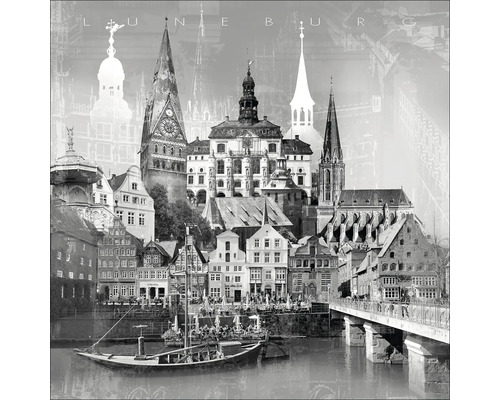 Schwarzweiß-Fotografie von Lüneburg mit Gebäuden, Kirchtürmen, Brücke und Fluss.