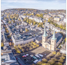 Luftaufnahme einer Stadt mit Kirche, Gebäuden und Bäumen