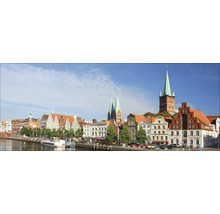 Panorama der Stadt Lübeck mit historischen Gebäuden, darunter Kirchen mit markanten Türmen, entlang eines Flusses
