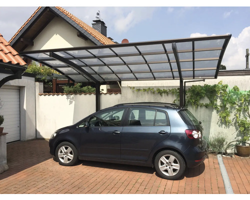 Auto unter einem Carport mit Polycarbonatdach auf einem gepflasterten Hof
