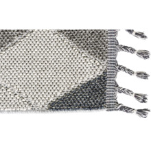 Detailansicht eines getufteten Teppichs mit Fransen