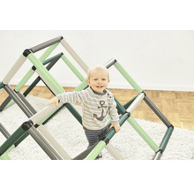 Kleinkind klettert auf einem Indoorklettergerüst für Kinder