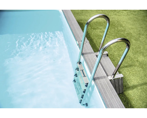 Aufnahme einer Poolleiter aus Metall, die in einen Pool mit Wasser führt.