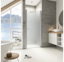 Helles Badezimmer mit Dusche, Waschbecken und Badewanne vor einem Fenster mit Seeblick