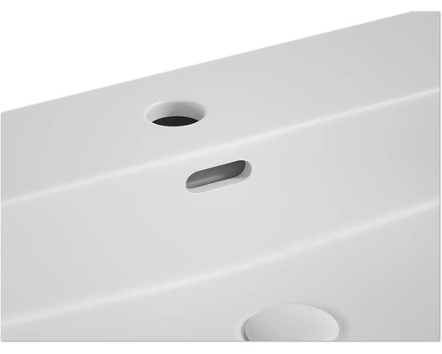 Detailansicht eines weißen Waschtisches mit Ablauf und Hahnloch