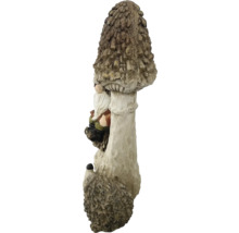 Gartenzwergfigur, die an einem Pilz lehnt, aus Kunststein gefertigt.