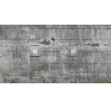 Betonwand mit Verwitterungsspuren und quadratischen Aussparungen