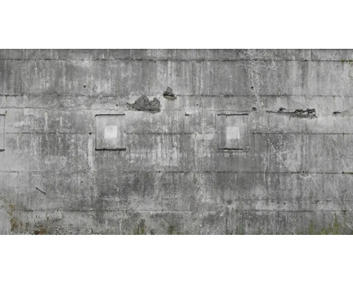 Betonwand mit Verwitterungsspuren und quadratischen Aussparungen