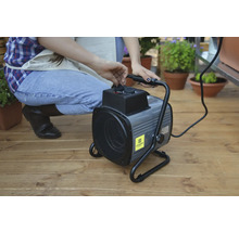 Eine Person bedient eine Elektroheizung für den Garten.