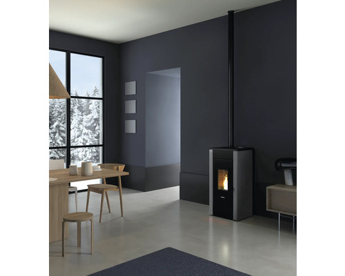 Wohnzimmer mit Pelletofen, Esstisch und Blick auf eine verschneite Landschaft