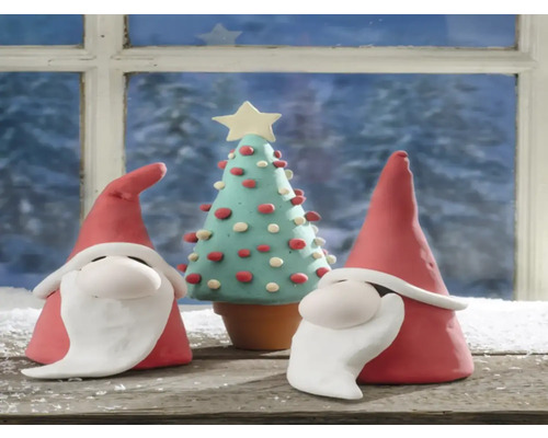 Weihnachtsszene mit zwei Wichteln und einem Weihnachtsbaum aus Ton vor einem Fenster