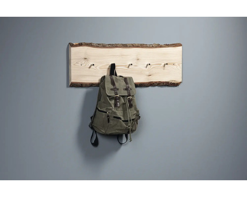 Holzgarderobe mit Rinde und aufgehängtem Rucksack