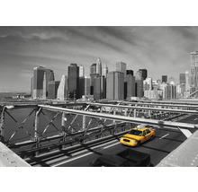 Gelbes Taxi auf der Brooklyn Bridge mit Skyline im Hintergrund