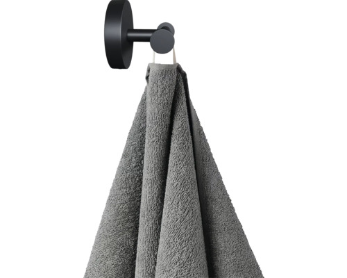 Graues Handtuch hängt an einem schwarzen Handtuchhaken
