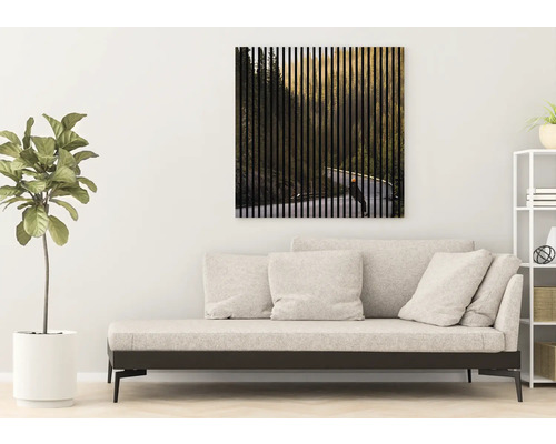 Wohnzimmer mit Sofa und Wandbild mit Waldmotiv