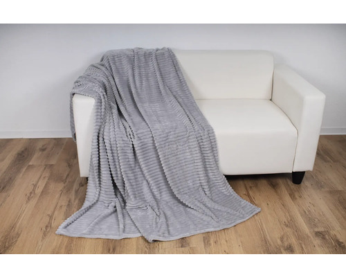 Graue Fleecedecke auf einem weißen Sofa