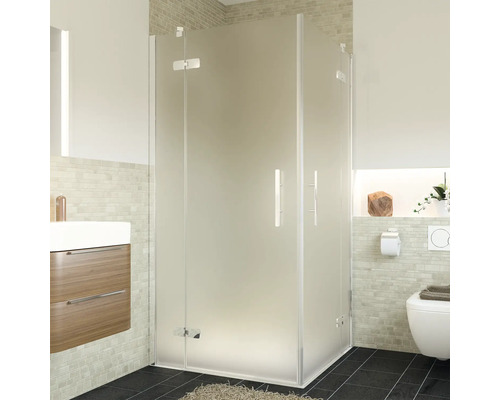 Eckdusche mit Milchglas in einem Badezimmer mit Waschbecken und Toilette.