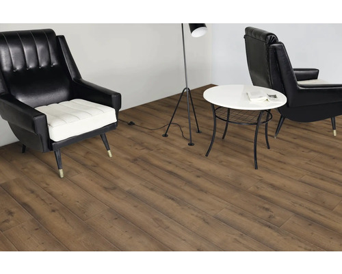 Wohnzimmer mit Laminatboden, Sessel und Tisch.