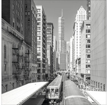 Schwarz-Weiß-Foto einer Stadtstraße mit Hochbahn und hohen Gebäuden