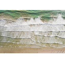 Luftaufnahme von Wellen, die auf einen Sandstrand treffen