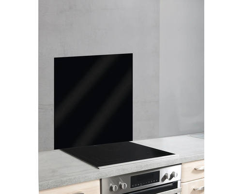 Schwarze Glasrückwand hinter einem Kochfeld in einer Küche
