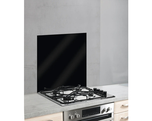 Küchenszene mit schwarzer Glasrückwand hinter einem Gasherd