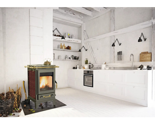 Helle Küche mit Holzofen, weißer Küchenzeile und Holzbalkendecke