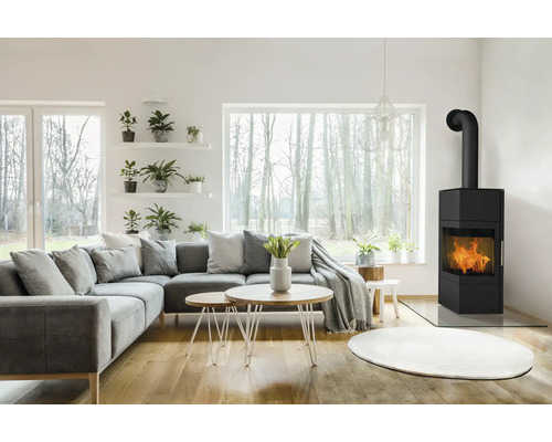 Wohnzimmer mit Ecksofa, Couchtischen und Kaminofen