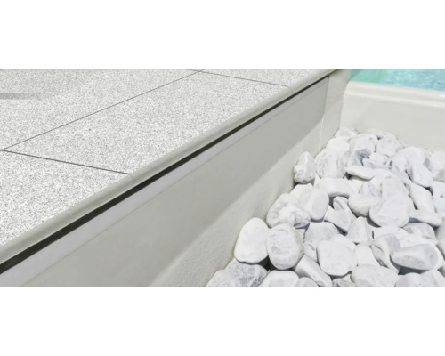 Detailaufnahme eines Pools mit Steinumrandung und weißen Ziersteinen.