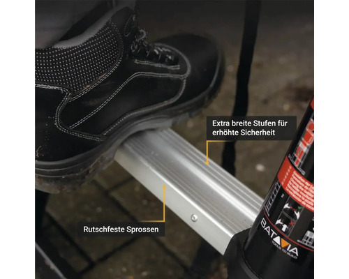 Detailaufnahme einer Trittstufe mit Antirutsch-Funktion und dem Fuß einer Person mit Sicherheitsschuhen.