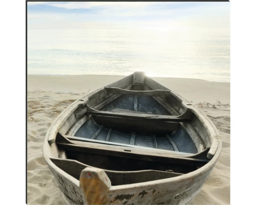 Ein hölzernes Ruderboot liegt am Strand.