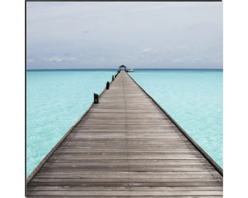 Eine lange Holzbrücke führt ins Meer.