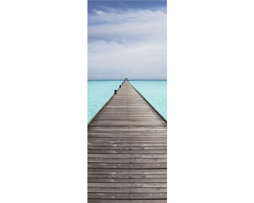 Langer Holzsteg über türkisfarbenes Wasser unter bewölktem Himmel