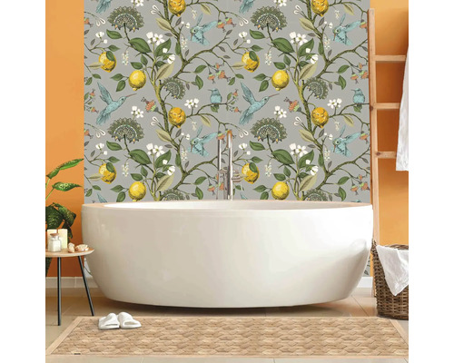 Badezimmer mit freistehender Badewanne und floral gemusterter Tapete mit Zitronen und Kolibris