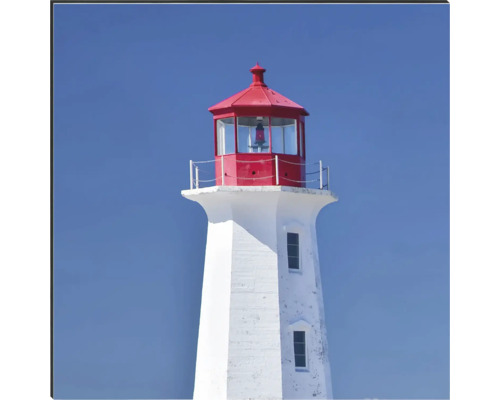 Ein weißer Leuchtturm mit rotem Dach gegen einen blauen Himmel