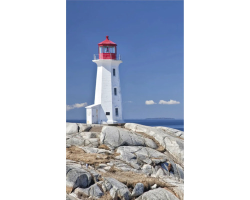 Ein weißer Leuchtturm mit roter Spitze steht auf felsigem Untergrund vor blauem Himmel.