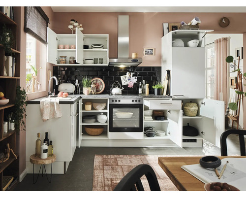 Küchenansicht mit weißen Schränken, schwarzen Fliesen und Küchenutensilien