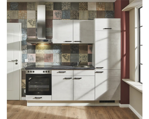 Kompakte Küchenzeile mit Spüle, Herd, Backofen und Dunstabzugshaube vor gemusterter Wand