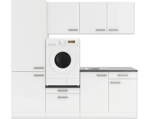 Waschküche mit Waschmaschine, Spüle und Schränken in Weiss