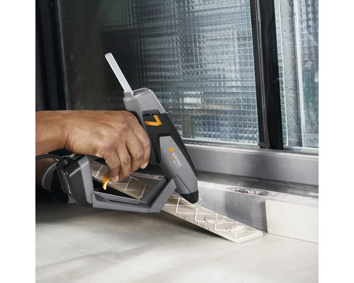 Eine Person benutzt eine Steinel Heißklebepistole zum Verkleben von Fliesen.