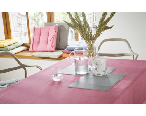 Tischdekoration mit Tischdecke, Tischsets, Vasen und Kissen auf einer Fensterbank