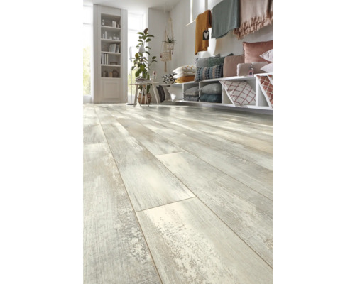 Heller Wohnraum mit Laminatboden in Holzoptik, Regalen, Kissen und Dekoration