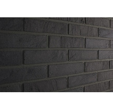 Nahaufnahme einer Wand mit dunklen Verblendsteinen