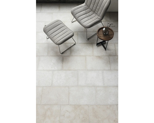 Fliesenboden im Innenraum mit Sessel und Beistelltisch.