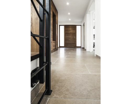 Flur mit Natursteinboden, Holztür und Garderobe