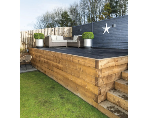 Gestalteter Gartenbereich mit Holzterrasse, Gartenmöbeln und dekorativer Bepflanzung