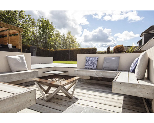 Gestalteter Gartenbereich mit Holzterrasse, Sitzbänken, Kissen und Feuerstelle