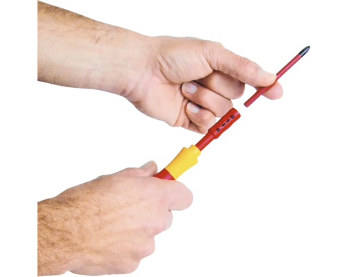 Ein Mann wechselt die Spitze eines Schraubendrehers.