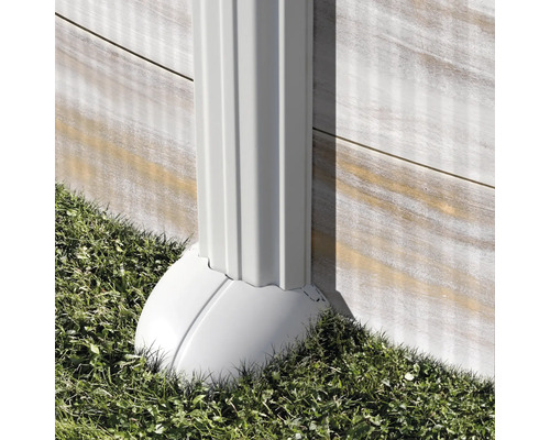Regenfallrohr aus Kunststoff an einer Hauswand mit Gras im Garten