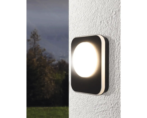 Quadratische Wandleuchte mit runder Lichtfläche an einer Fassade